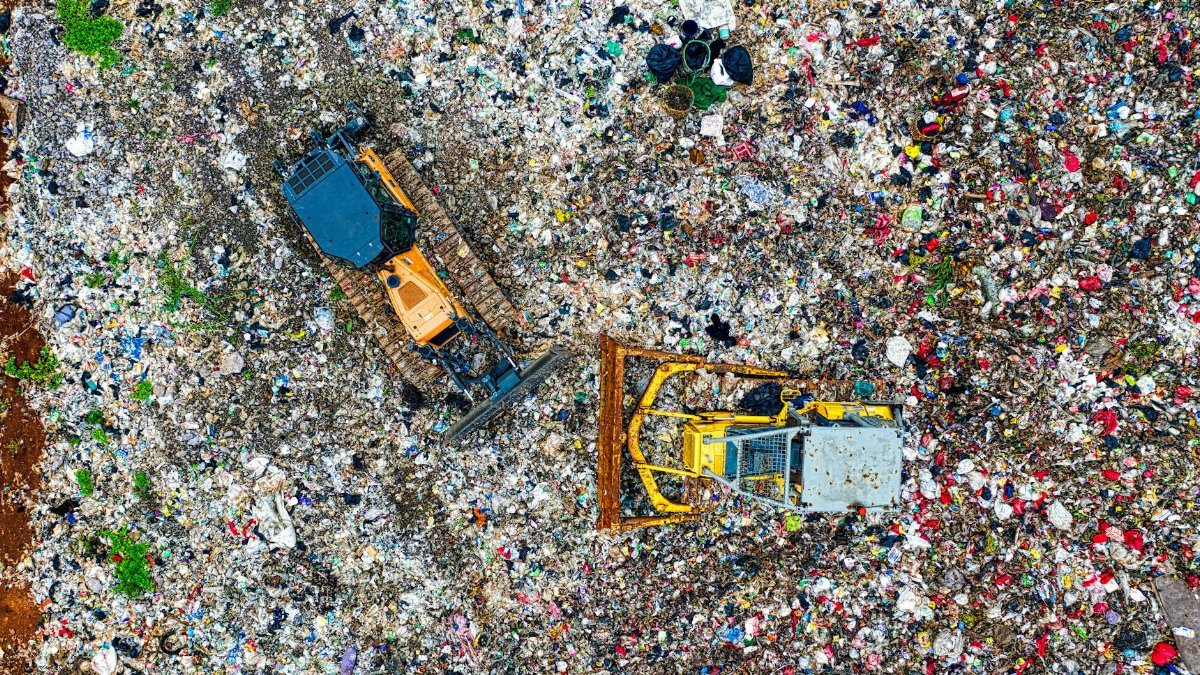 Drones capture heavy machinery managing waste at Banten dumpsite, Indonesia.