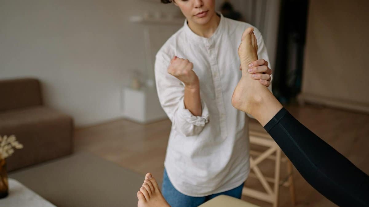 A massage therapist gives a relaxing foot therapy session in a calm indoor setting.
