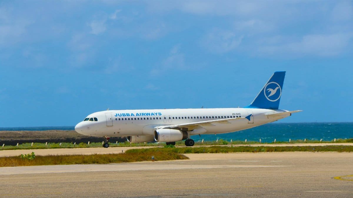 Jubba Airways plane parked at Mogadishu's seaside airport runway during daylight.