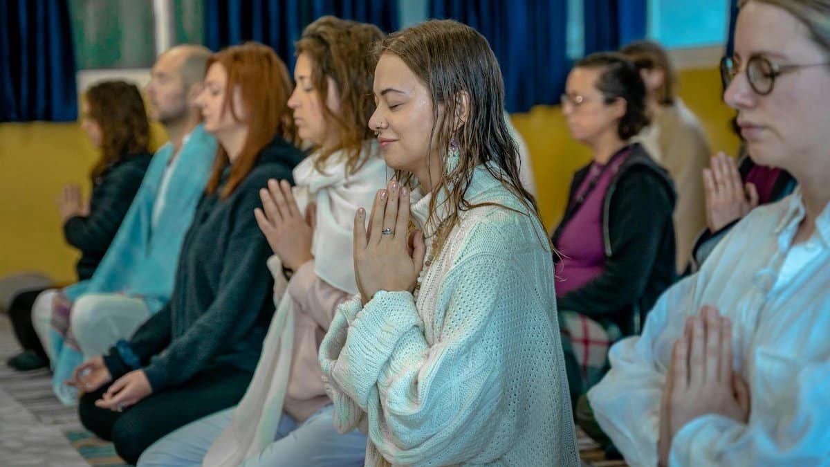 People in a meditative pose at a spiritual retreat in Rishikesh, India.