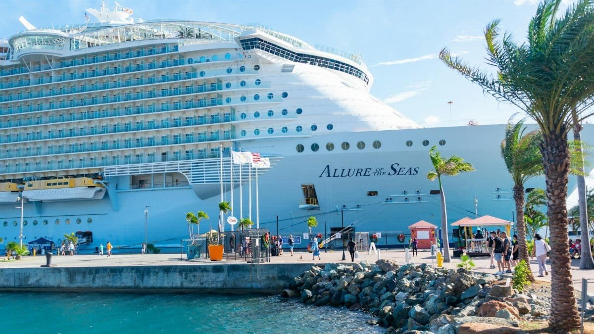 Discover the majestic Allure of the Seas docked in a vibrant tropical port.