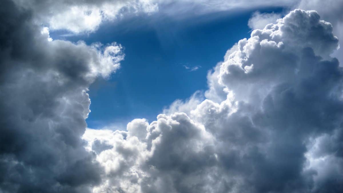 Dramatic clouds with sunlight shining through, creating a dynamic sky scene.