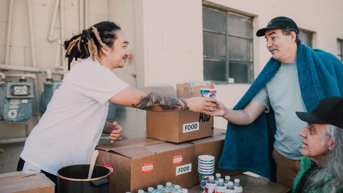 Volunteers distribute food and aid packages to those in need, fostering community support.