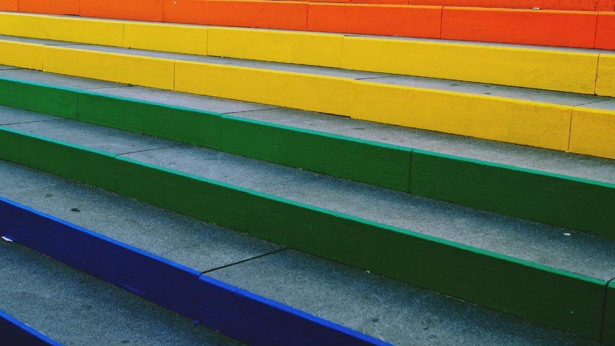 Vibrant rainbow-colored steps create a striking urban art display, perfect for background and design inspiration.