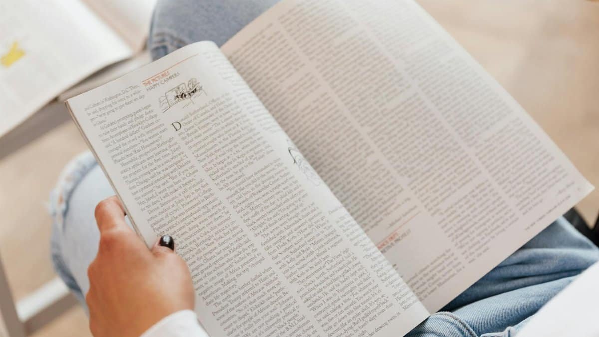 A woman enjoys reading a magazine in a cozy indoor setting, showcasing leisure time and relaxation.
