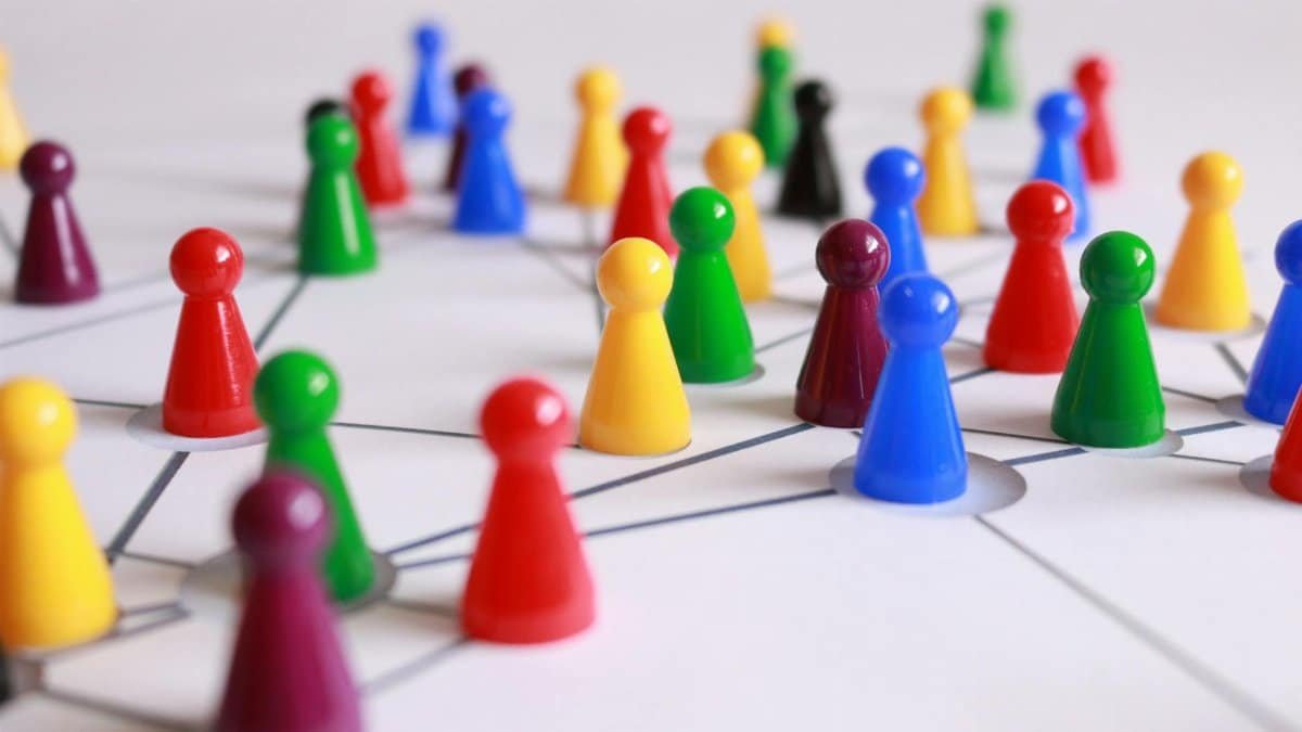 A strategic arrangement of colorful pawns connected on a game board, symbolizing networking and teamwork.