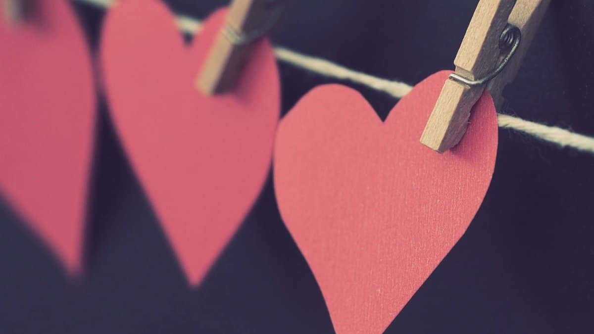 Close-up of red paper hearts hanging on a clothesline, perfect for Valentine's Day themes.