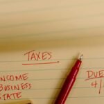 Close-up of tax-related notes on a yellow legal pad with red pen, highlighting important due dates.