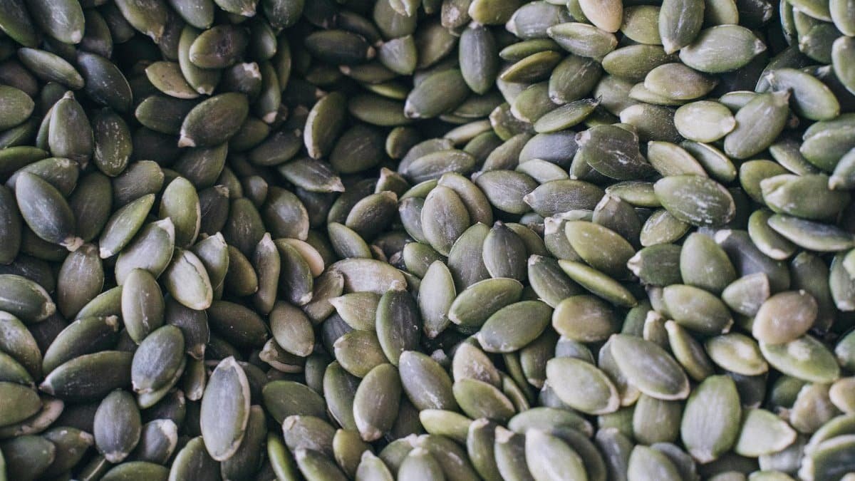 A close-up shot of organic pumpkin seeds showcasing their natural texture and green hue.