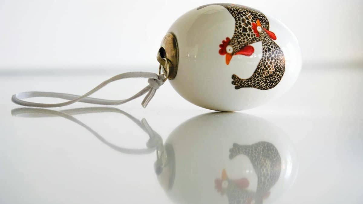 Close-up of a handmade Easter egg ornament featuring a charming chicken illustration, perfect for festive decorations.