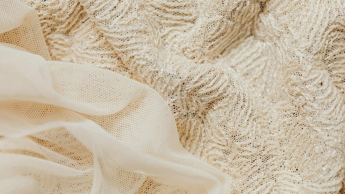 Close-up view of intricate beige lace fabric and sheer material, ideal for fashion and textile projects.