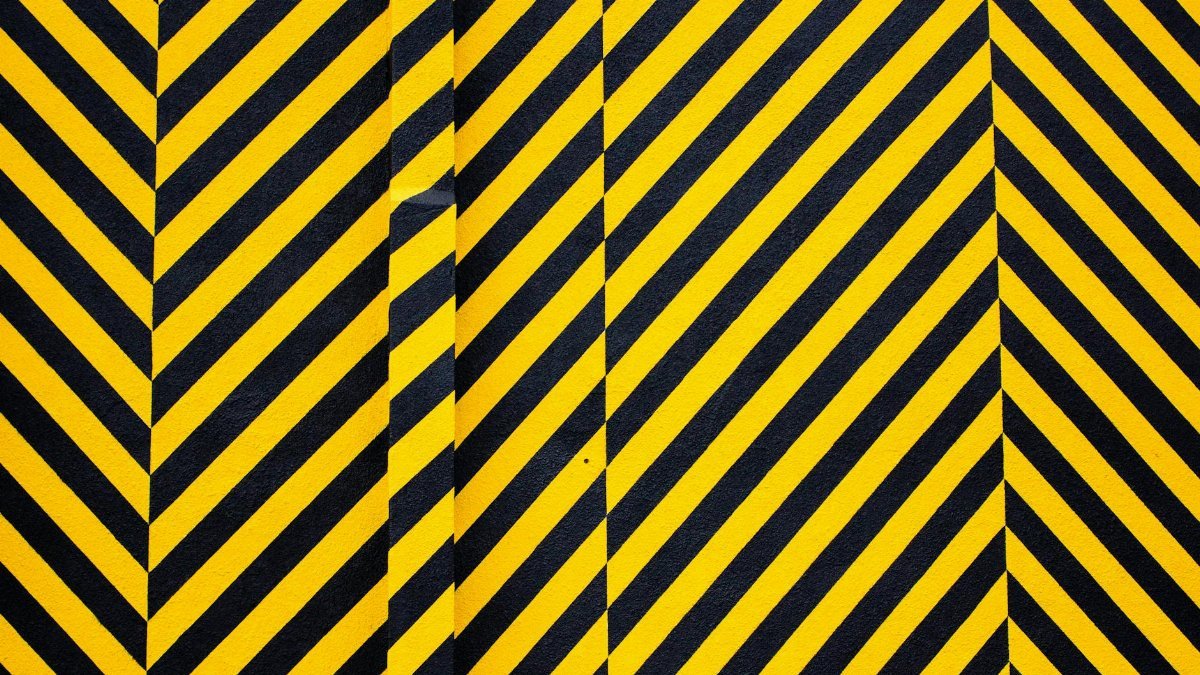 Dynamic yellow and black patterned background with bold diagonal stripes for creative design use.
