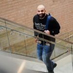 A student confidently ascends steps inside South Texas College of Law building.