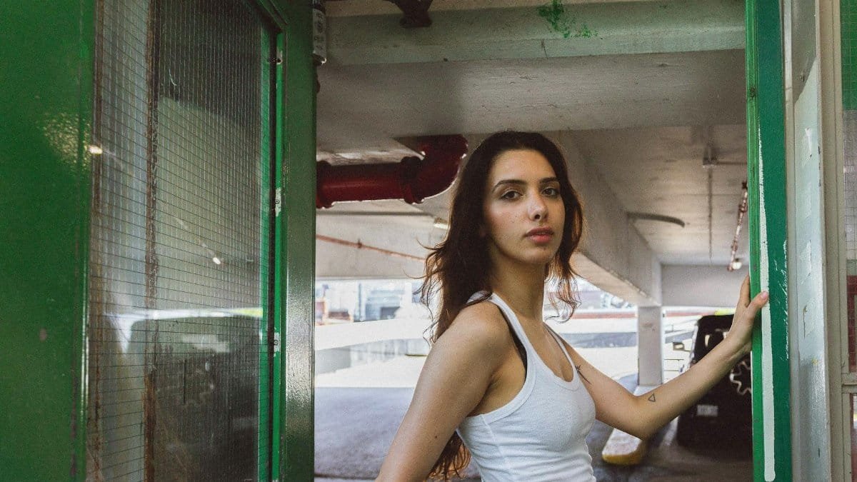 A young woman poses confidently in an urban area, exuding style and allure.