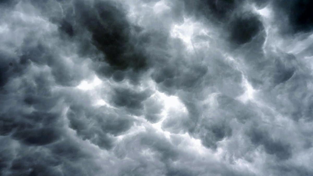 Majestic storm clouds fill the sky, creating a dramatic, moody atmosphere.