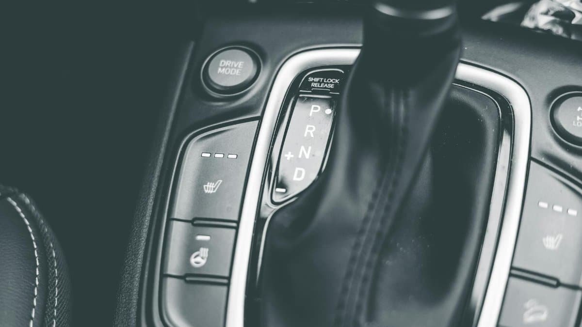 Close-up of a gear shift lever in a modern car, captured in black and white.