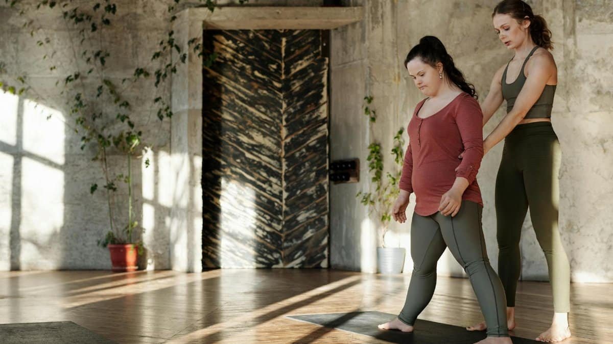 Two women practicing yoga in a sunlit studio, focusing on balance and mindfulness.
