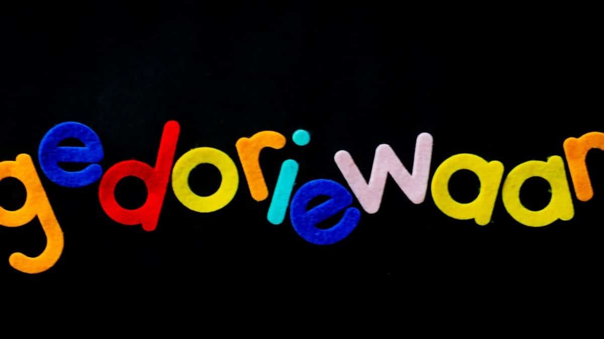Bright multicolored felt letters spelling a creative word on a black background.