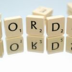 Scrabble tiles spelling 'words' on glass reflecting surface, perfect for language and games themes.