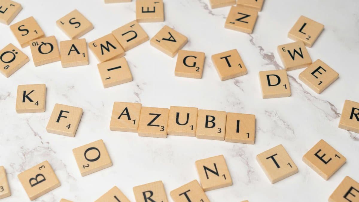 Wooden letter tiles arranged to form words on a white marble surface, perfect for education and creativity themes.