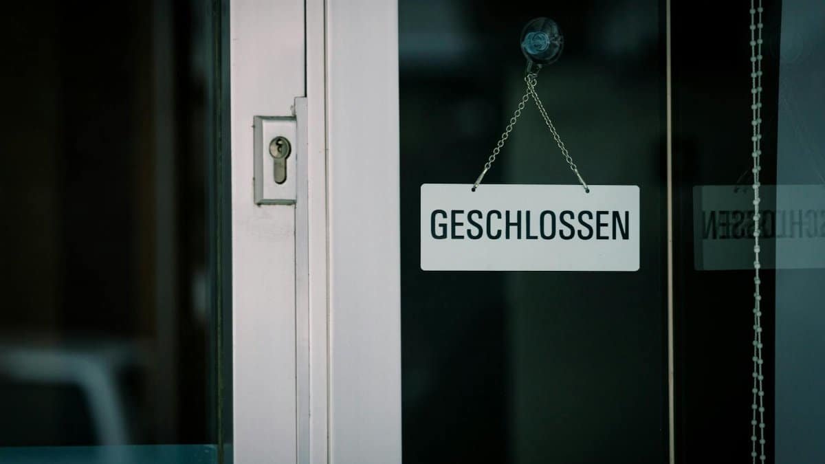 A close-up view of a 'Geschlossen' sign hanging on a door, indicating closure.
