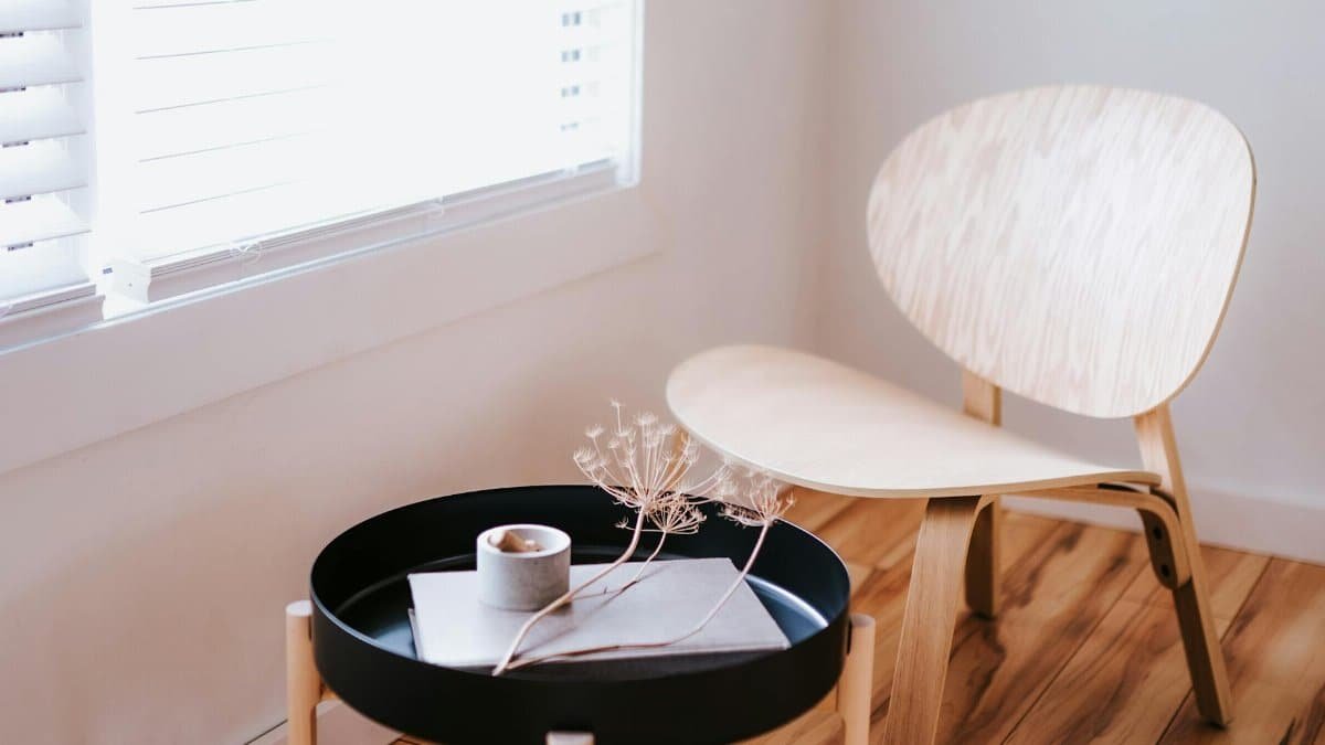 Elegant Japandi style room with a wooden chair, round table, and decorative items.