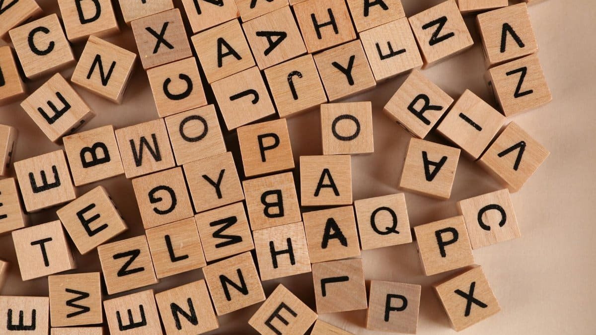 Close-up of scattered wooden alphabet blocks, ideal for educational and playful themes.