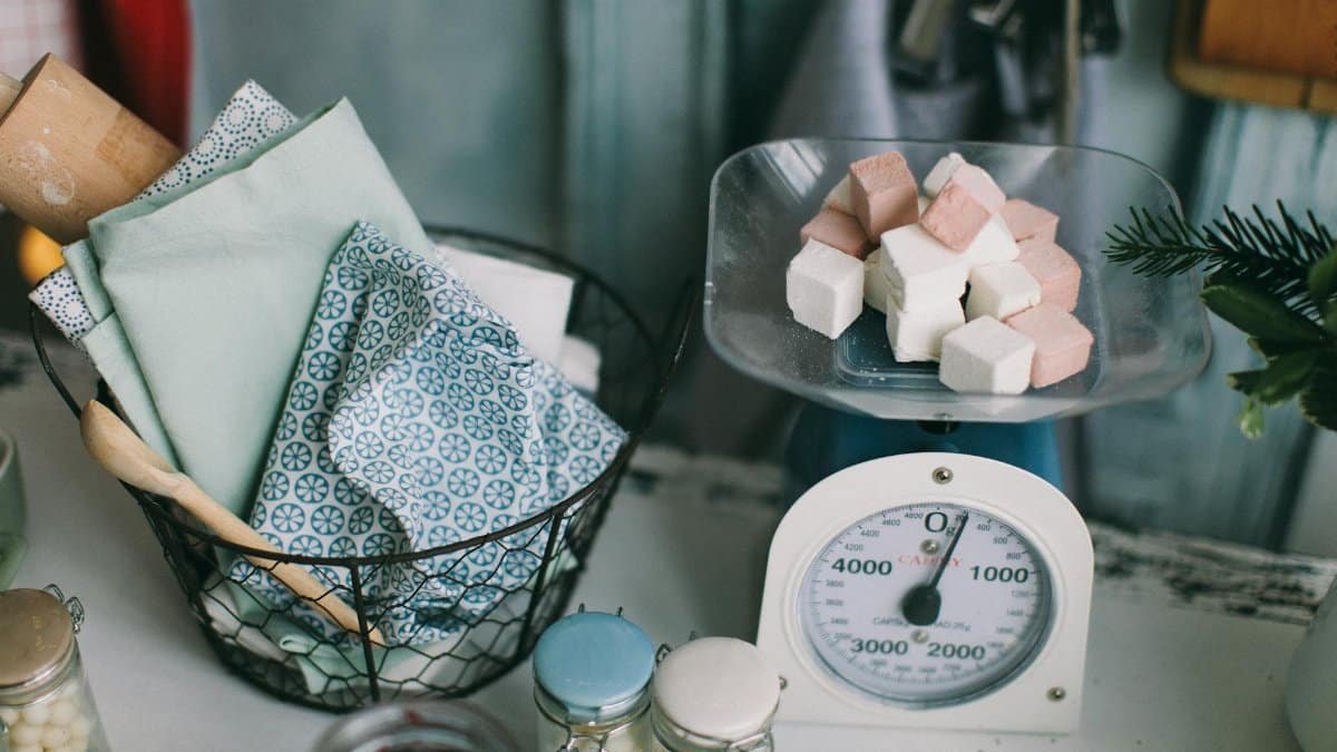 A charming kitchen setup showcasing baking essentials and sugar cubes on a scale.