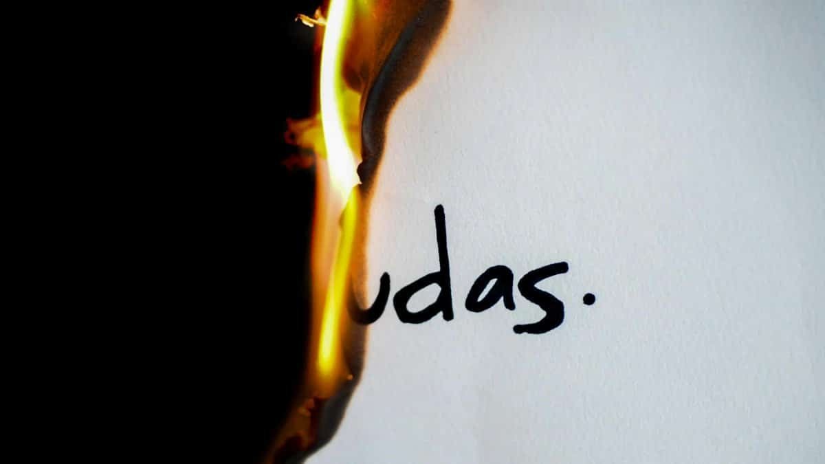 A piece of paper with handwritten text 'udas' partially engulfed in flames.