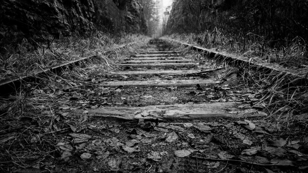 Black and white photo of abandoned railroad tracks with a moody feel.