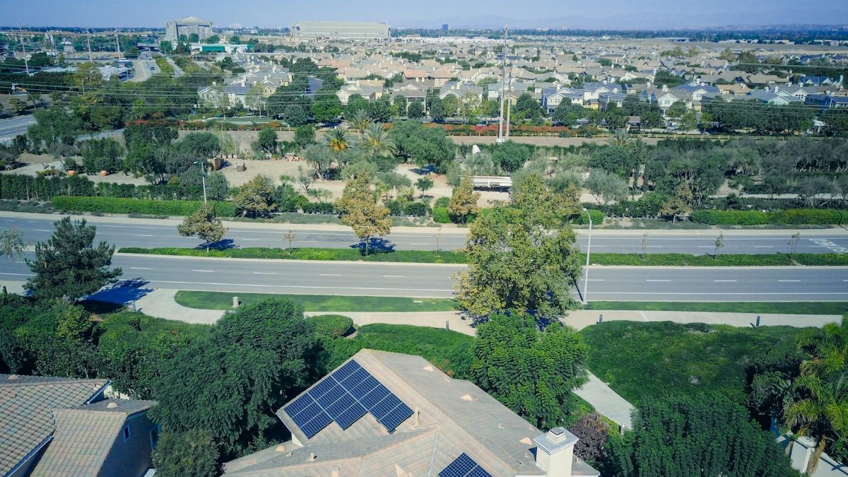 Aerial view showing suburban houses with solar panels, showcasing clean energy.