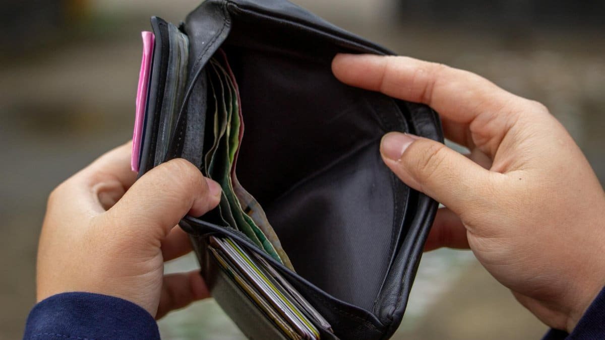 Hands holding an empty wallet, exploring themes of financial strain and budgeting.