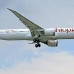 Ethiopian Airlines Boeing 787 Dreamliner in flight against a clear sky.