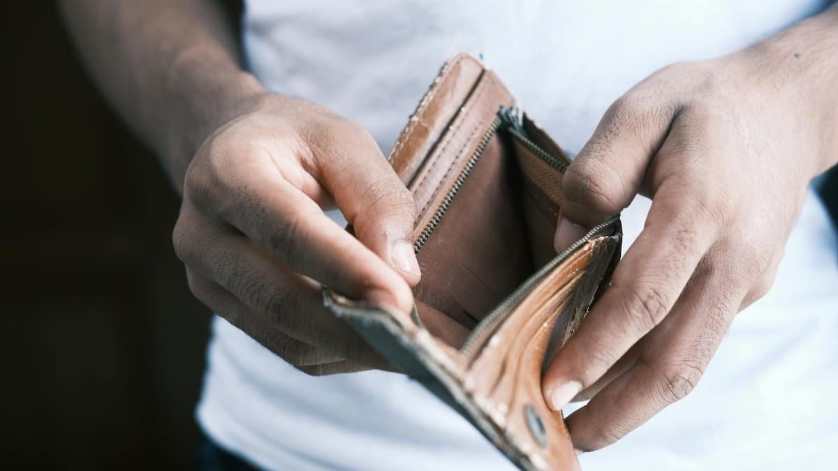 Close-up of hands holding an empty wallet, highlighting financial struggles and economic crisis.