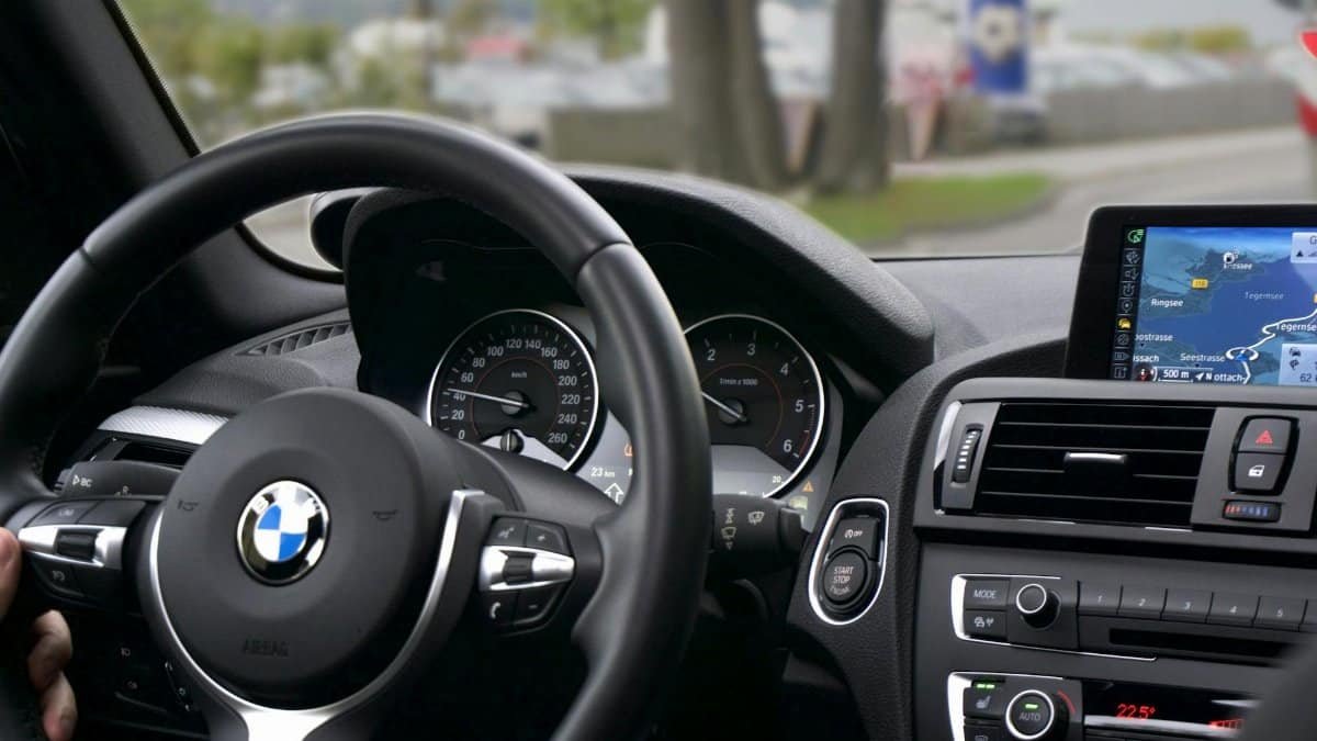 Elegant BMW car interior showcasing navigation screen, speedometer, and steering wheel.