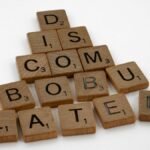 Scrabble tiles arranged to spell 'discombobulated' on a clean white surface, ideal for concept art.