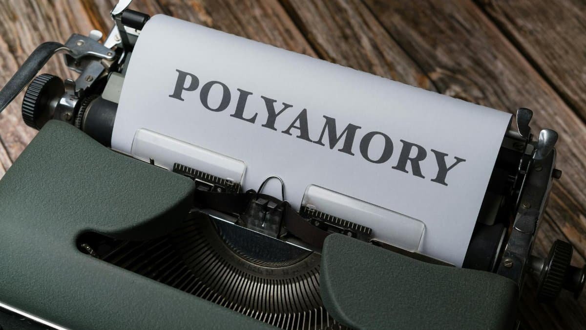 A classic typewriter displaying the word 'Polyamory' on wooden background.