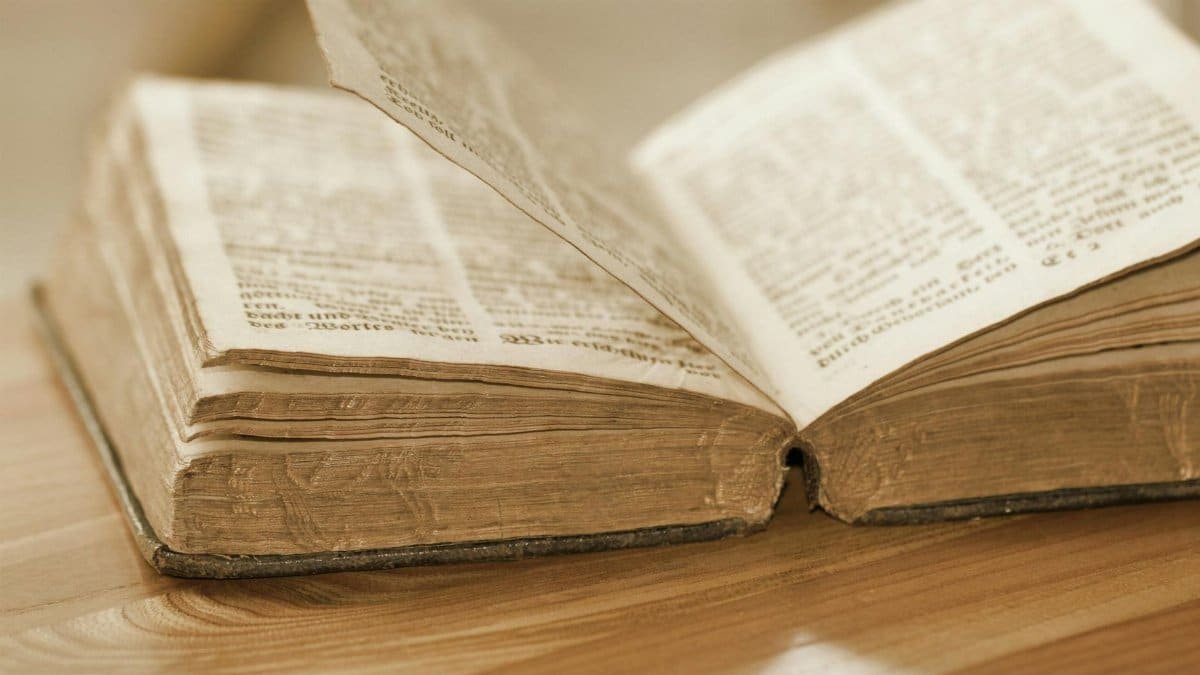 Vintage open book on a wooden table, highlighting old pages and text, perfect for knowledge and history themes.