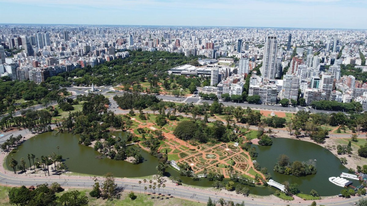 Aerial view showcasing Buenos Aires skyline with lush parks and water features in the foreground.
