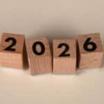 Wooden cubes forming the year 2026 on a neutral background.