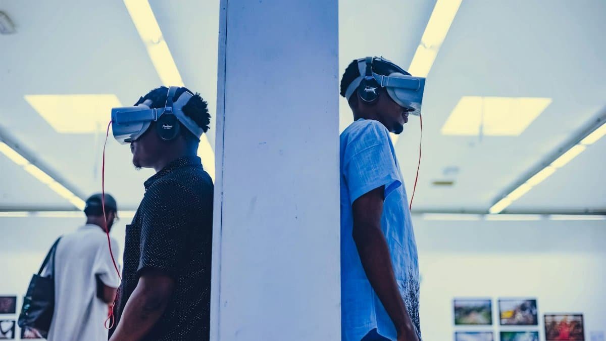 Two men using VR headsets in a modern indoor gallery setting.