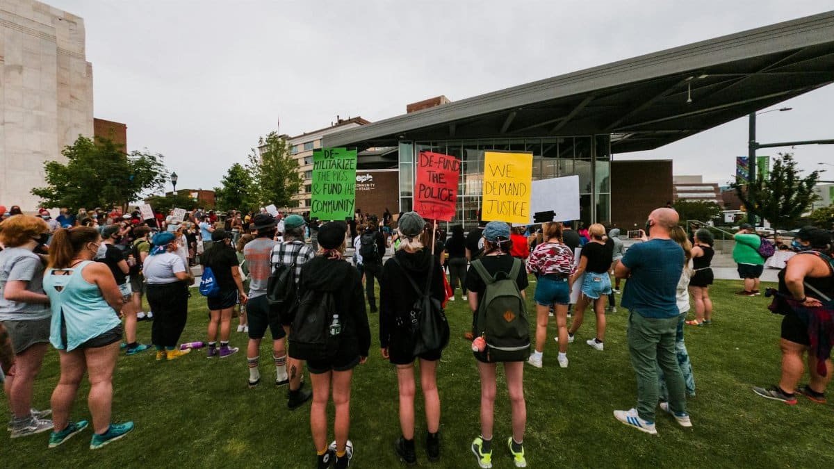A diverse group of protesters demand justice in Chattanooga city park.