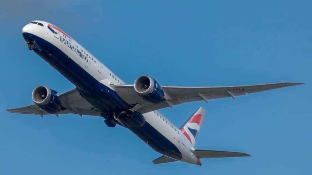British Airways airplane in flight against a clear blue sky, showcasing aviation excellence.