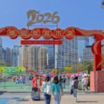 Crowds enjoying the vibrant 2026 Lunar New Year Fair at Victoria Park, Hong Kong under clear blue skies.