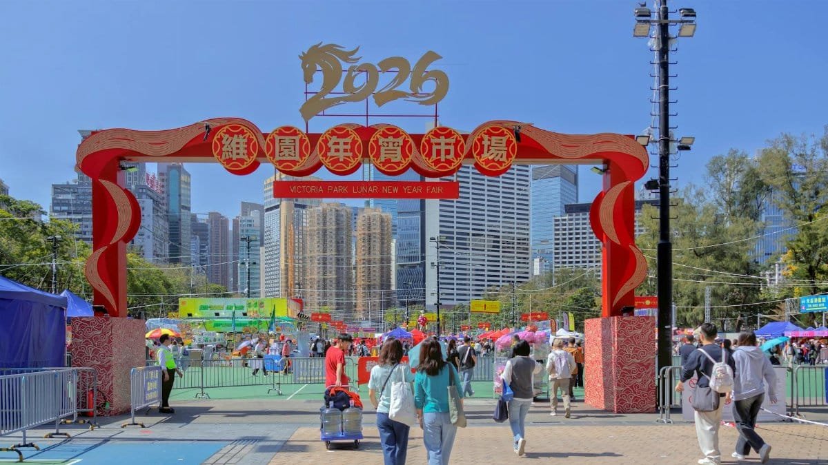 Crowds enjoying the vibrant 2026 Lunar New Year Fair at Victoria Park, Hong Kong under clear blue skies.