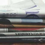 A stack of folded newspapers placed on a wooden table, symbolizing news and information.