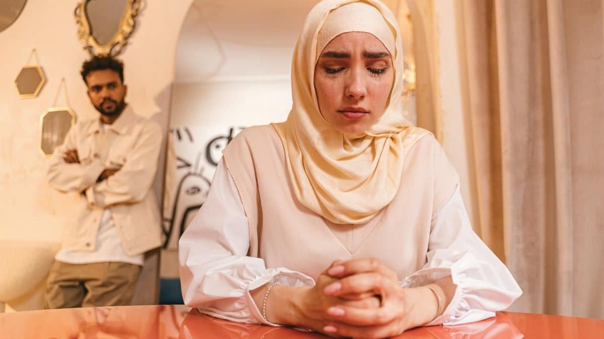 Young couple experiencing relationship tension, woman deeply upset indoors.