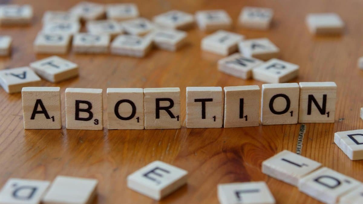 Scrabble tiles spelling 'abortion', highlighting the debate on reproductive rights.
