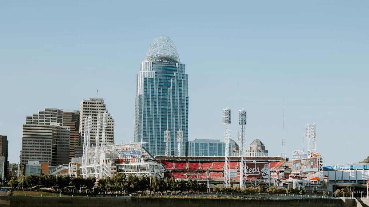 Photo of Cincinnati skyline with Great American Ball Park and modern skyscrapers, captured from a riverside view.