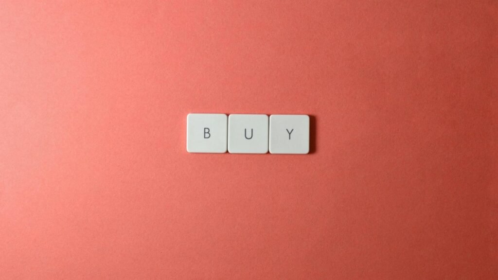 Keyboard keys spelling 'BUY' on a coral background, ideal for e-commerce themes.